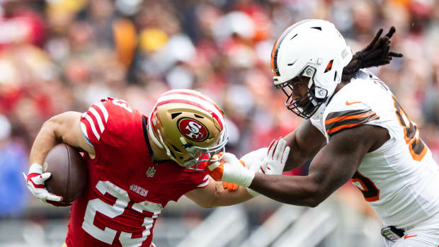 Oct 15, 2023; Cleveland, Ohio, USA; San Francisco 49ers running back Christian McCaffrey (23) runs the ball as Cleveland Browns defensive end Za'Darius Smith (99) grabs him by the face mask during the first quarter at Cleveland Browns Stadium.
